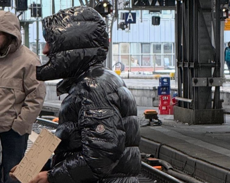 „Așa arată sărăcia în Germania”: cerșetor cu geacă Moncler și pantofi Adidas, filmat în Gara din Köln. Imaginile au stârnit controverse