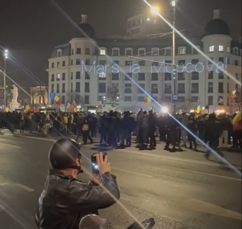 Mesajul „Marș la Moscova” proiectat pe clădirile din Piața Universității sub privirile manifestanților pro Georgescu / Autorul a avut același mesaj pentru Georgescu la 1 decembrie la Alba Iulia