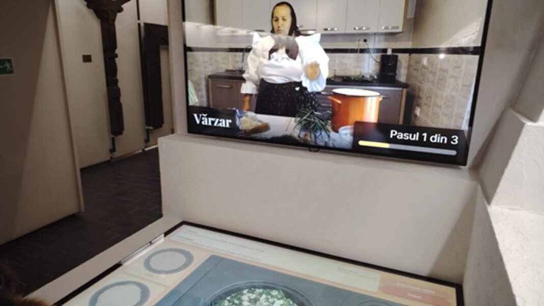 VIDEO | Gătit virtual, experiență inedită la Muzeul Etnografic din Sighetu Marmației / Vizitatorii „gătesc” pe o plită care e de fapt un ecran touch, ghidați de socăcițe